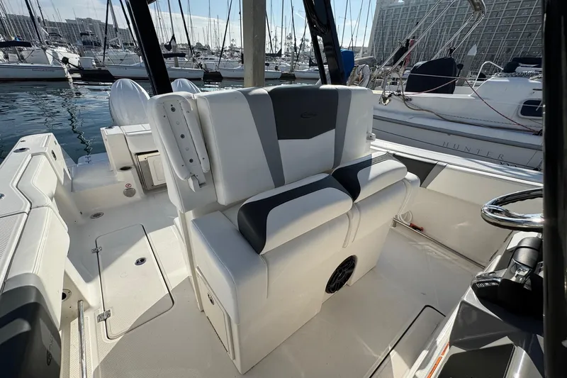 Slide: The Image of 2025 Robalo R270 Center Console boat interior with seating and steering wheel in marina. - 43