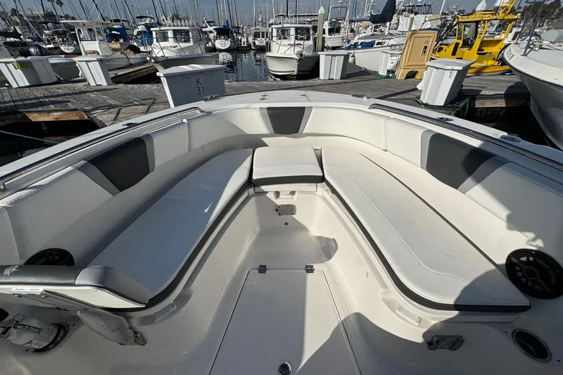 Slide: The Image of 2025 Robalo R270 Center Console boat interior with spacious seating at a marina. - 47
