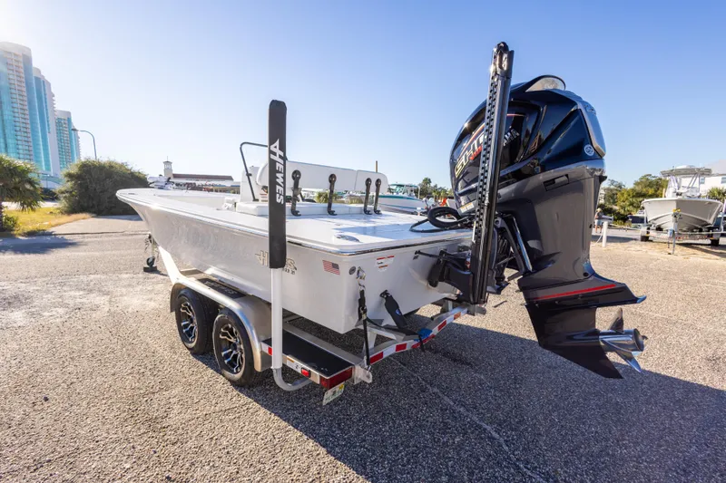 Slide: The Image of 2023 Hewes Redfisher 21 boat on trailer, parked outdoors under clear blue sky. - 12