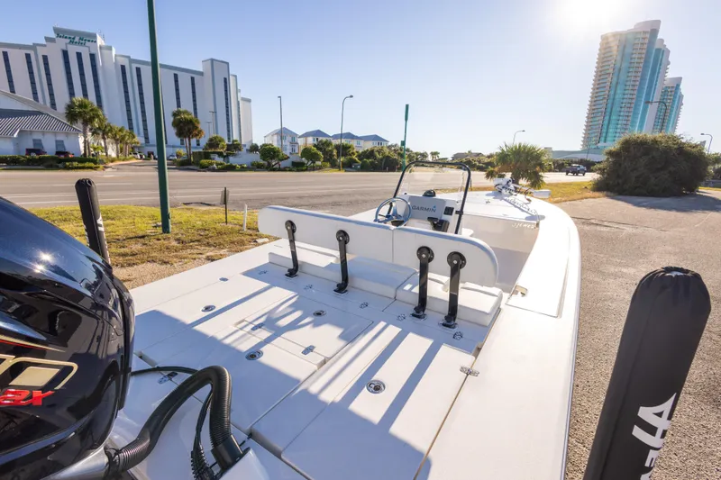 Slide: The Image of 2023 Hewes Redfisher 21 boat parked near modern buildings under clear sky. - 13