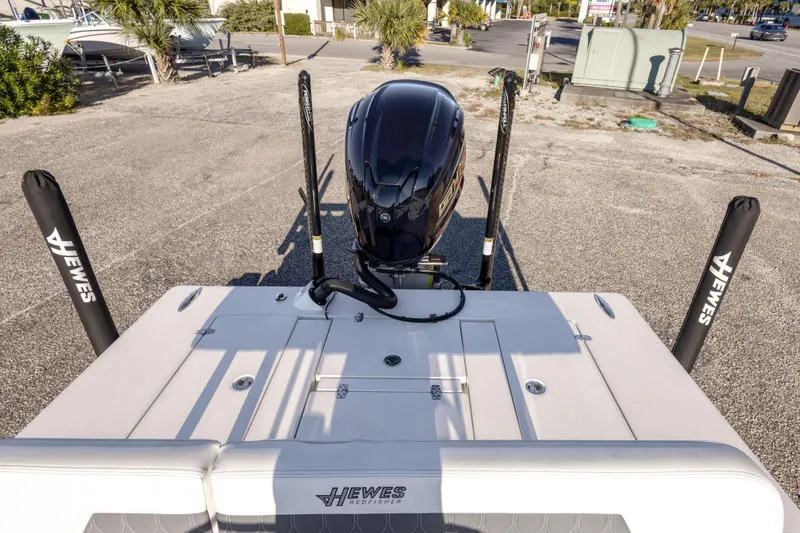 Slide: The Image of 2023 Hewes Redfisher 21 boat with powerful outboard motor, parked on a sunny day. - 22
