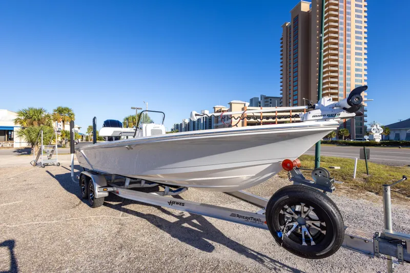Slide: The Image of 2023 Hewes Redfisher 21 boat on trailer, urban background, clear blue sky. - 5
