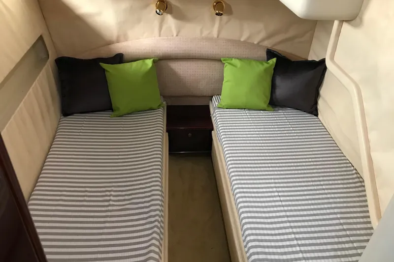 Slide: The Image of Twin beds with striped bedding and colorful pillows in a 1996 Princess yacht cabin. - 12