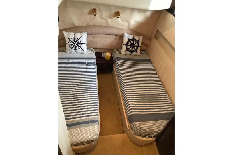 Slide: The Image of Twin beds with nautical-themed pillows in a 1996 Princess model yacht cabin. - 13