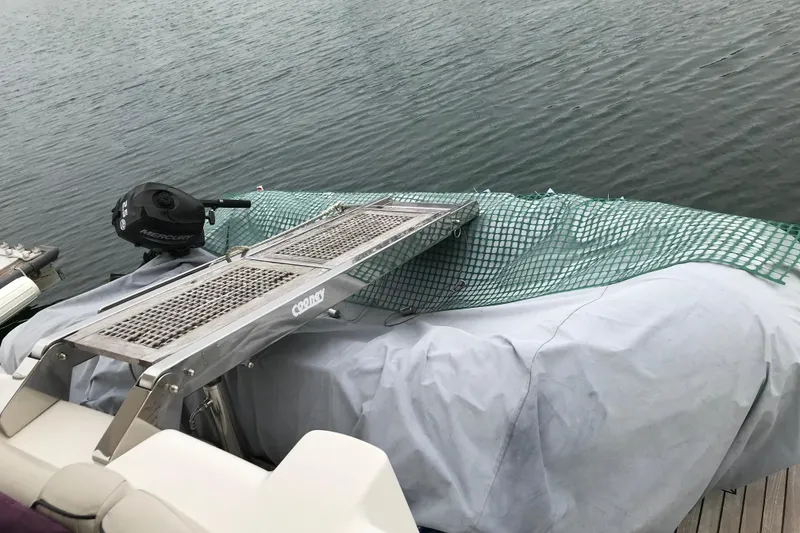 Slide: The Image of Covered 1996 Princess boat with a Mercury engine and metal boarding ladder. - 21