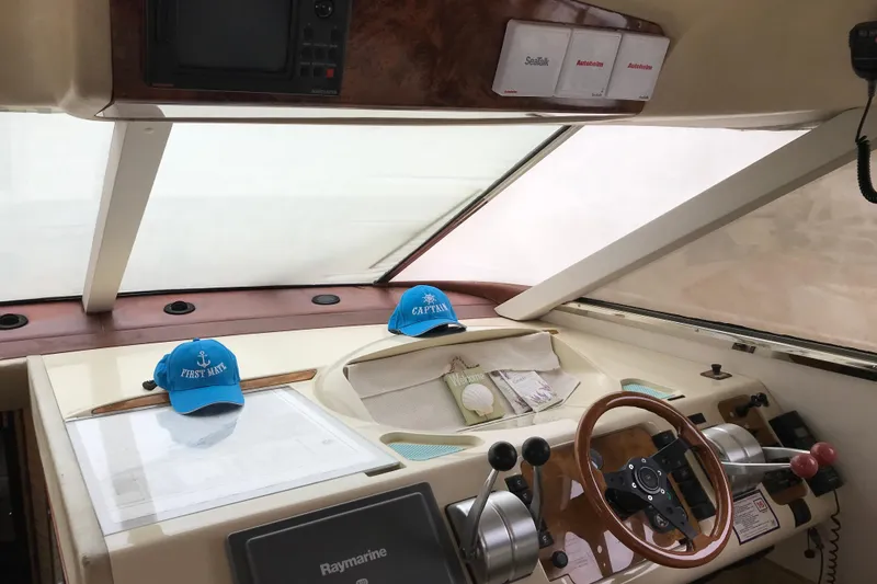 Slide: The Image of 1996 Princess boat helm with captain and first mate hats, featuring Raymarine equipment. - 9