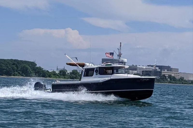 The Image of 2019 Ranger Tugs R-23 cruising on water with American flag, scenic background. - 0