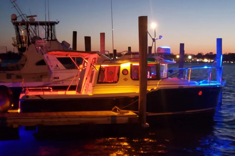 Slide: The Image of 2019 Ranger Tugs R-23 boat docked at sunset with colorful lights. - 1