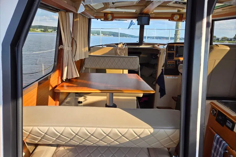 Slide: The Image of Interior of 2019 Ranger Tugs R-23 boat with seating and table, overlooking water. - 4