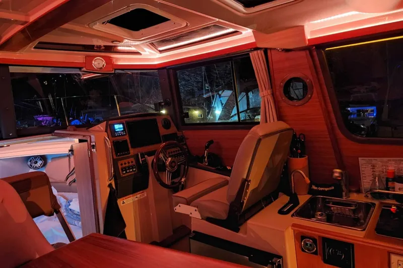 Slide: The Image of Interior of 2019 Ranger Tugs R-23 boat with illuminated dashboard and cozy seating. - 6