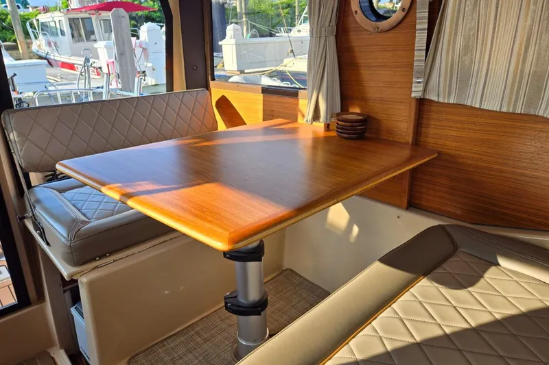 Slide: The Image of Interior of 2019 Ranger Tugs R-23 with wooden table and cushioned seating. - 7