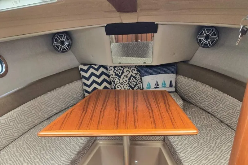 Slide: The Image of 2019 Ranger Tugs R-23 cabin interior with wooden table and patterned cushions. - 9