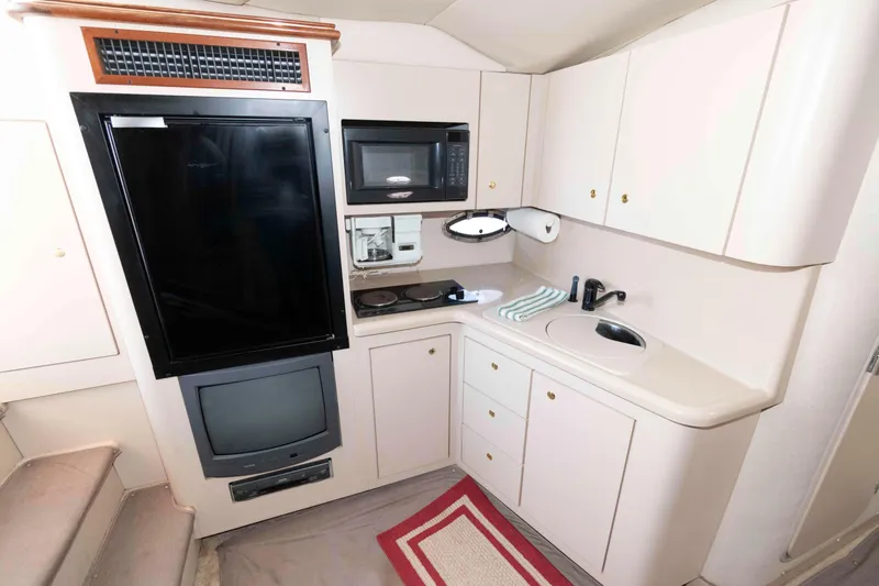 Slide: The Image of 1999 Cruisers Yachts 3575 Express kitchen with appliances, sink, and storage cabinets. - 12