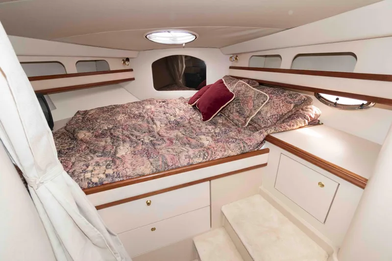 Slide: The Image of Luxurious cabin interior of 1999 Cruisers Yachts 3575 Express with cozy bedding and elegant wood accents. - 13