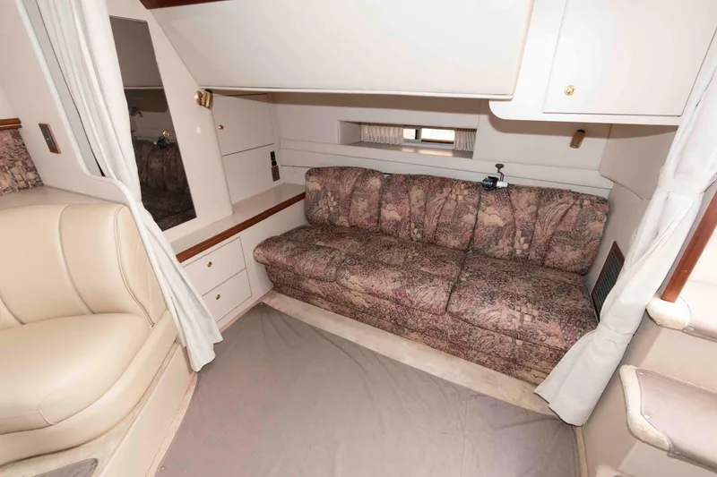 Slide: The Image of 1999 Cruisers Yachts 3575 Express interior with patterned sofa and cream leather seating. - 14
