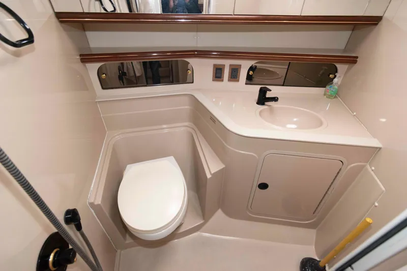 Slide: The Image of 1999 Cruisers Yachts 3575 Express bathroom with toilet, sink, and mirror. - 15