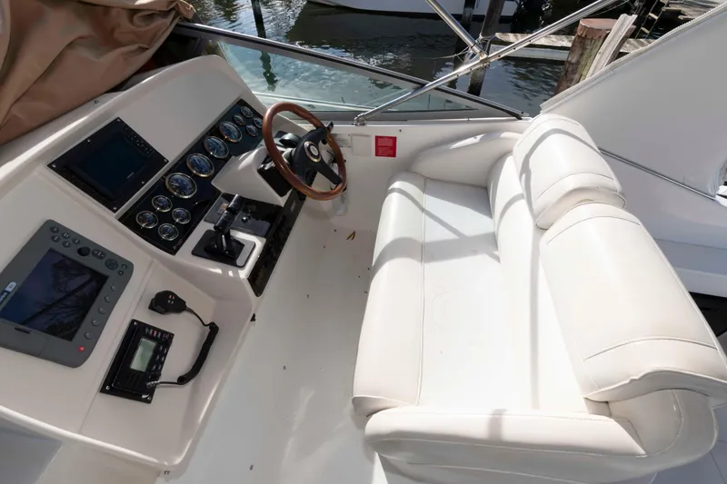 Slide: The Image of 1999 Cruisers Yachts 3575 Express helm with white seating and modern controls. - 5