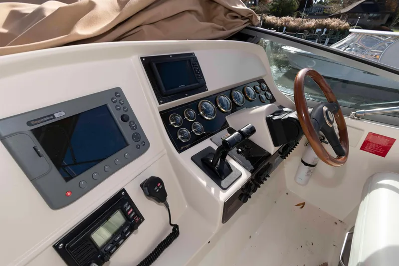 Slide: The Image of 1999 Cruisers Yachts 3575 Express helm with navigation instruments and wooden steering wheel. - 6