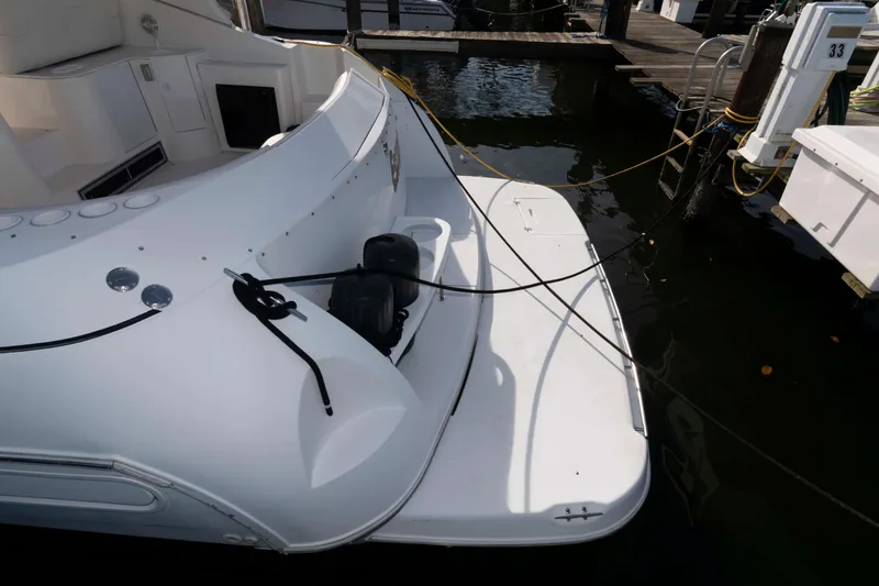 Slide: The Image of 1999 Cruisers Yachts 3575 Express docked, showing rear deck and mooring lines. - 9