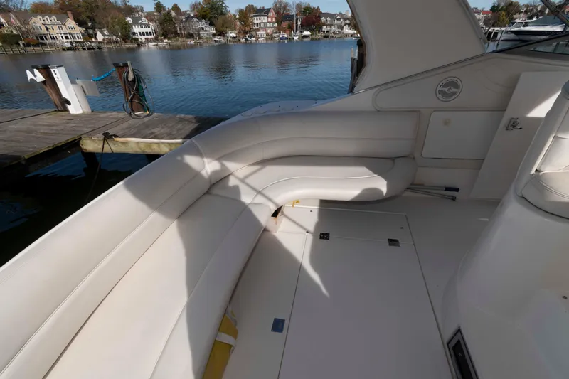 Slide: The Image of 1999 Cruisers Yachts 3575 Express interior with white seating, dockside view. - 3