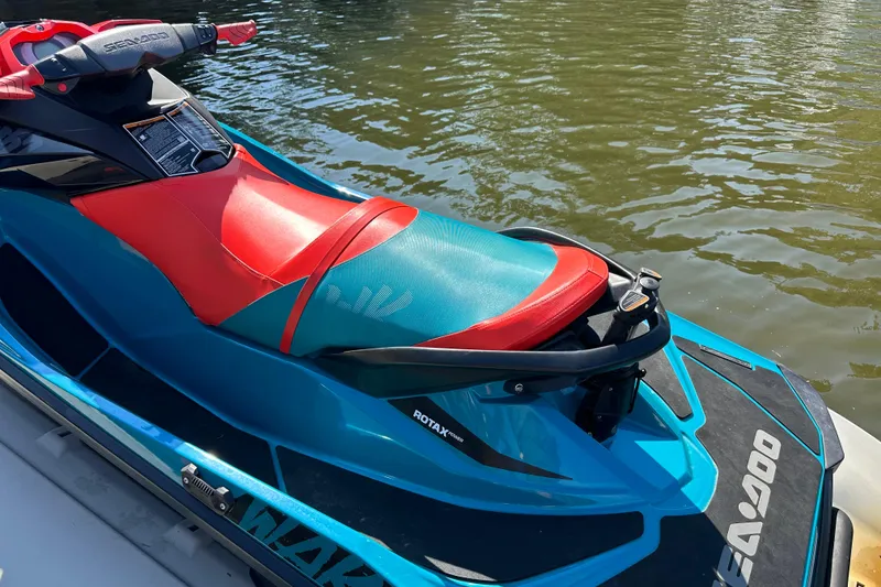 Slide: The Image of 2019 Sea-Doo Wake 155 jet ski with vibrant red and teal seat on water. - 6