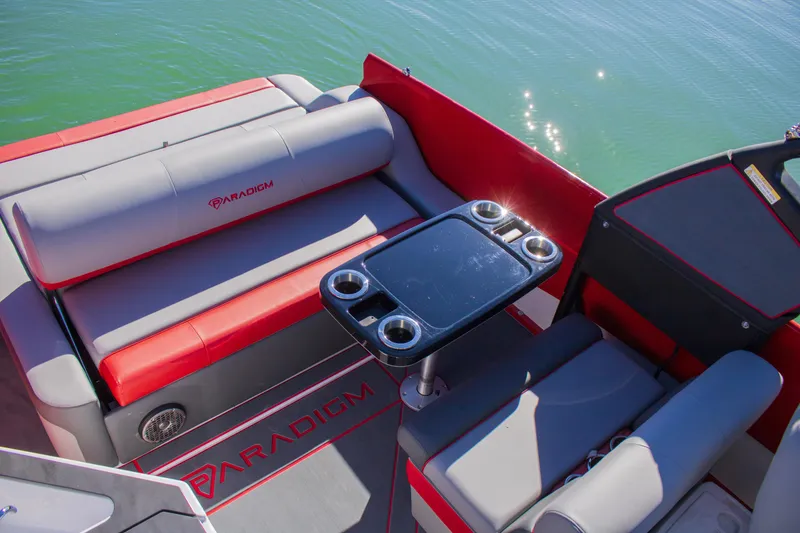 Slide: The Image of 2024 Paradigm Damascus 296 Surf boat interior with red and gray seating and table. - 10
