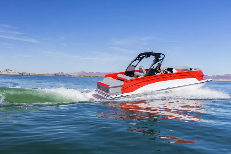 Slide: The Image of 2024 Paradigm Damascus 296 Surf boat cruising on a clear lake under a blue sky. - 13