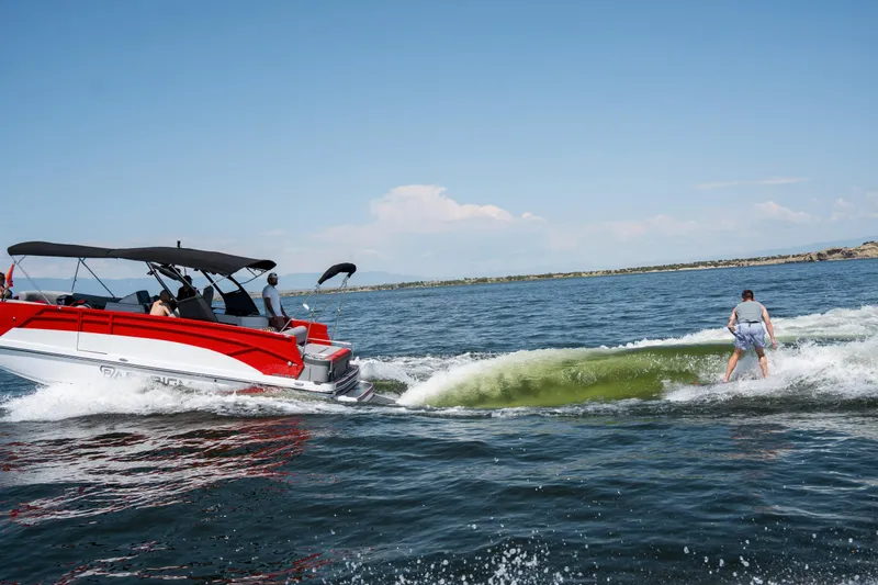 Slide: The Image of 2024 Paradigm Damascus 296 Surf boat towing a wakeboarder on a sunny lake. - 15