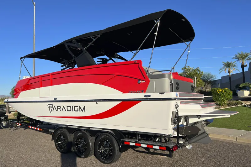 Slide: The Image of 2024 Paradigm Damascus 296 Surf boat on trailer, red and white design, sunny day. - 2