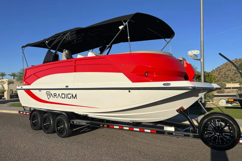 Slide: The Image of 2024 Paradigm Damascus 296 Surf boat on trailer, red and white design, sunny day. - 6