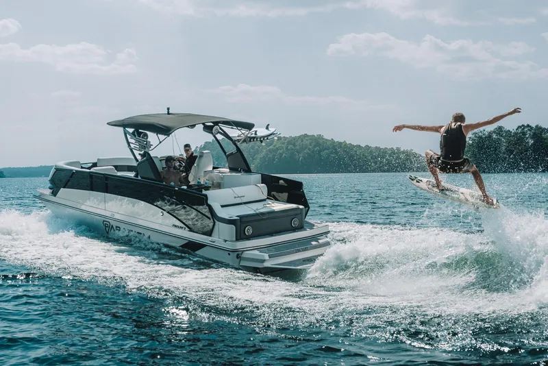 Slide: The Image of Manufacturer Provided Image: 2024 Paradigm Damascus 296 Surf boat towing a wakeboarder on a sunny lake. - 8