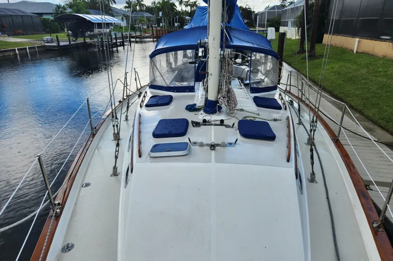 Slide: The Image of 1990 Catalina/Morgan 44 Center Cockpit sailboat docked by a serene waterfront. - 2