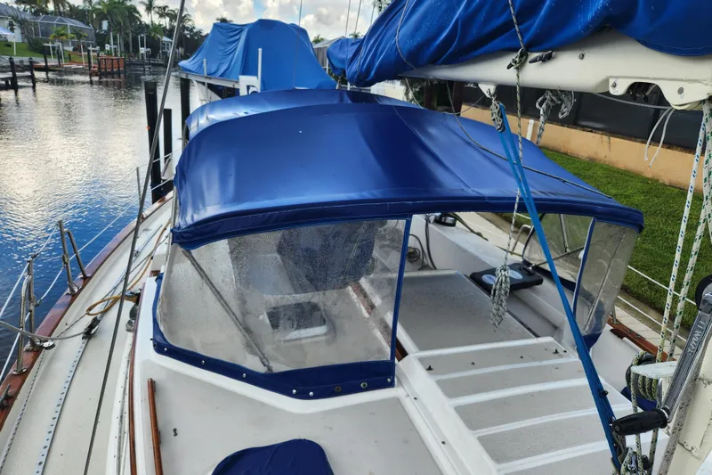 Slide: The Image of 1990 Catalina/Morgan 44 Center Cockpit sailboat with blue canopy docked by the water. - 4