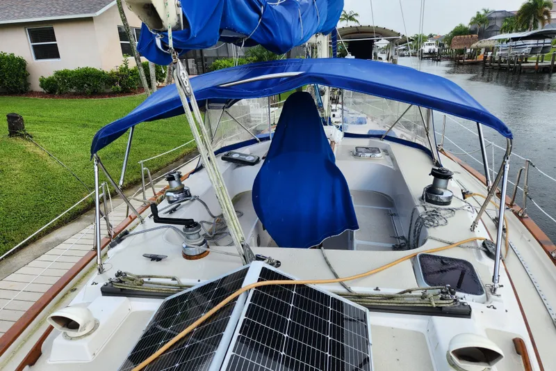Slide: The Image of 1990 Catalina/Morgan 44 Center Cockpit sailboat with blue canopy and solar panels. - 6