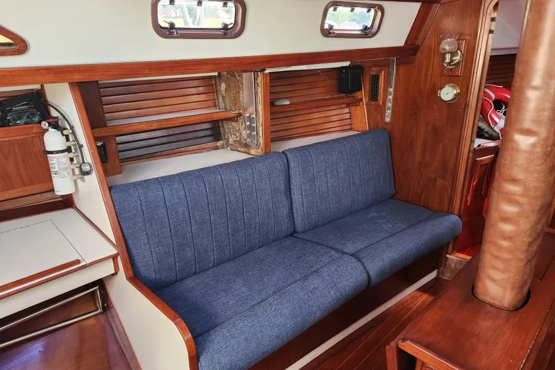 Slide: The Image of Interior of 1990 Morgan 44 Center Cockpit with blue sofa and wooden accents. - 9