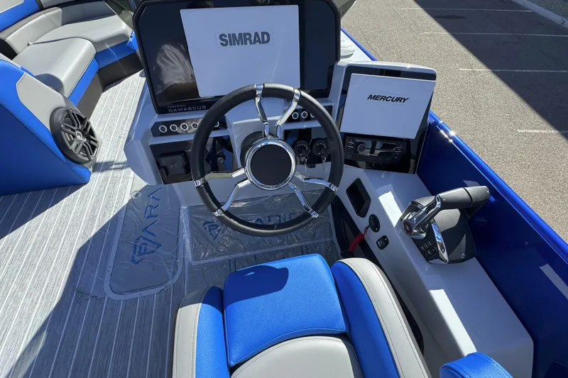 Slide: The Image of 2025 Paradigm 27SST boat cockpit with Simrad and Mercury controls, blue seating. - 4
