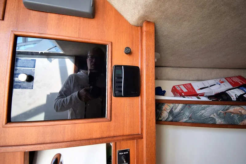 Slide: The Image of Interior of 2007 Carolina Classic 28 Express boat with wooden paneling and storage area. - 18