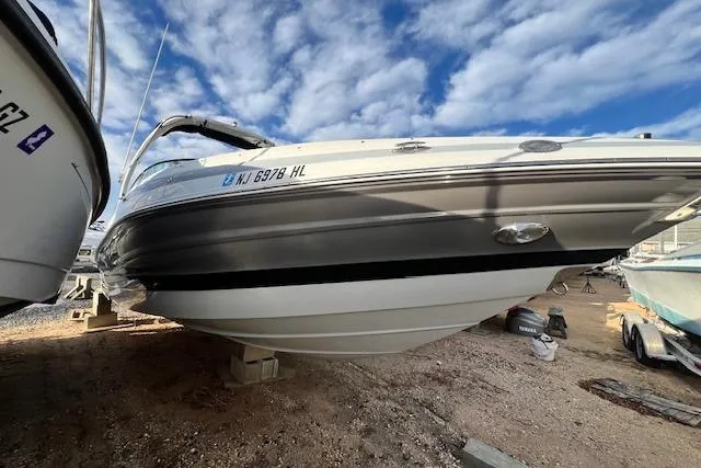 The Image of 2021 Crownline 265 SS boat on dry dock under a partly cloudy sky. - 0