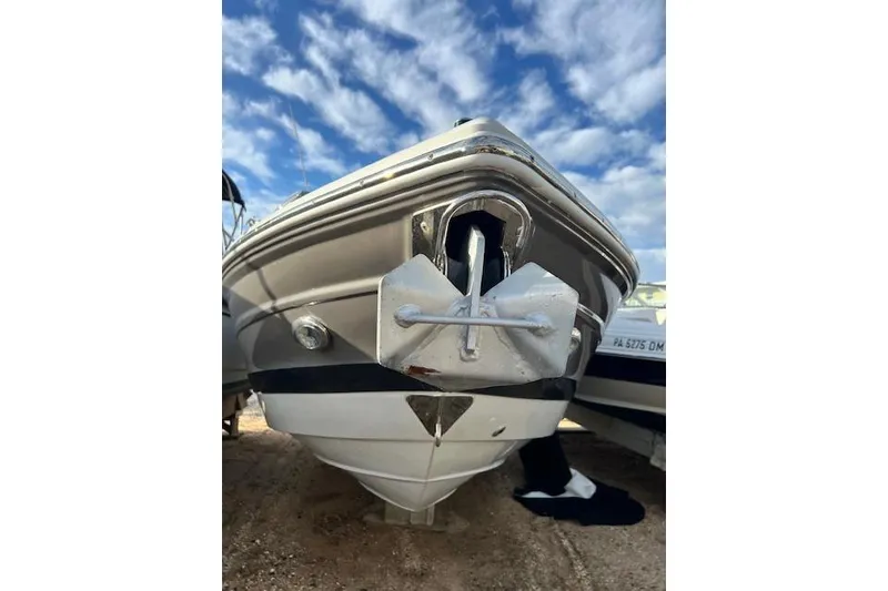 Slide: The Image of 2021 Crownline 265 SS boat with anchor, under a blue sky. - 2