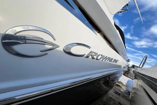 Slide: The Image of 2021 Crownline 265 SS boat with logo, under a clear blue sky. - 22