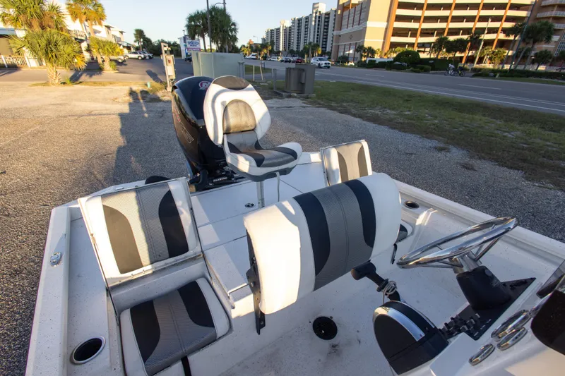 Slide: The Image of 2020 Vexus AVX1980CC boat interior with seating and steering wheel, parked near a road. - 17