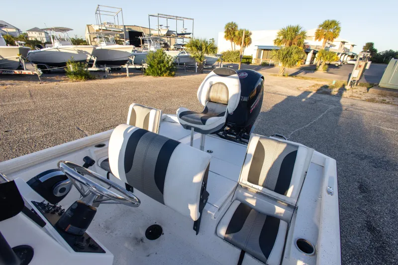 Slide: The Image of 2020 Vexus AVX1980CC boat interior with steering wheel and seating, parked outdoors. - 21