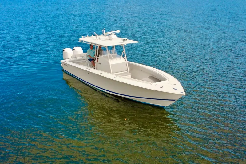 Slide: The Image of 2006 Jupiter 31FS boat on calm blue water, featuring twin engines and sleek design. - 10