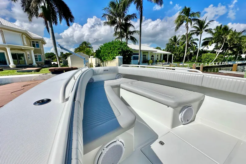 Slide: The Image of 2006 Jupiter 31FS boat interior with luxurious seating, docked near palm trees and waterfront homes. - 26