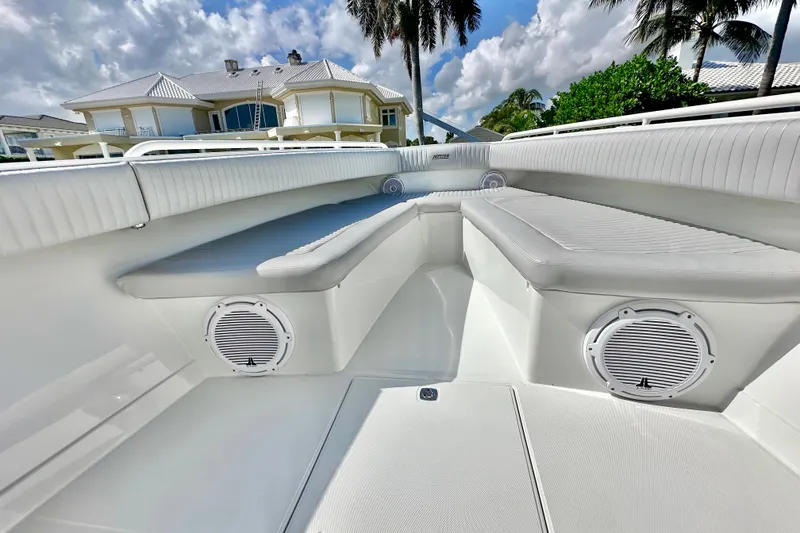 Slide: The Image of Luxurious 2006 Jupiter 31FS boat interior with cushioned seating and speakers, under a sunny sky. - 27