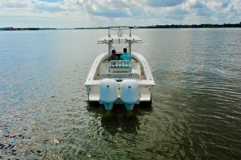 Slide: The Image of 2006 Jupiter 31FS boat on calm water, featuring dual outboard motors. - 3