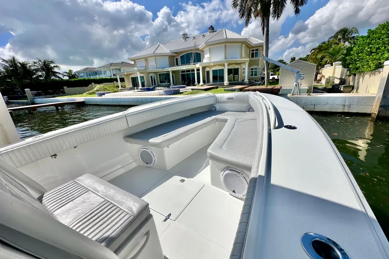 Slide: The Image of 2006 Jupiter 31FS boat docked near luxury waterfront home under blue sky. - 30