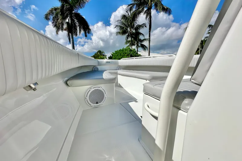 Slide: The Image of 2006 Jupiter 31FS boat interior with white seating, palm trees, and blue sky background. - 31