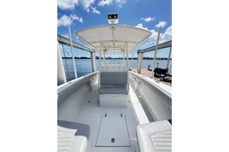 Slide: The Image of 2006 Jupiter 31FS boat interior with seating, docked by the water under a clear sky. - 33