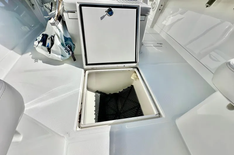 Slide: The Image of Open storage compartment on 2006 Jupiter 31FS boat deck, featuring clean white interior. - 35